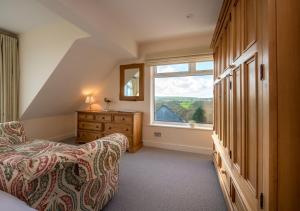 a bedroom with a bed and a dresser and a window at The Summer House in Abersoch