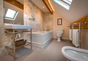 a bathroom with a sink and a tub and a toilet at The Summer House in Abersoch