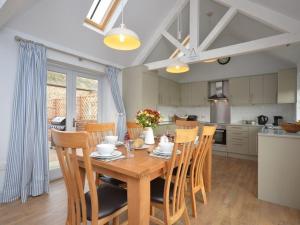 a dining room table with chairs and a kitchen at 2 Bed in Winterton-on-Sea LOWFA in Winterton-on-Sea