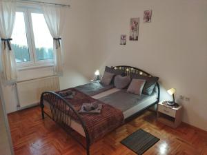 een slaapkamer met een bed en een groot raam bij DORA Apartman in Palić