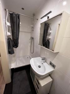 a white bathroom with a sink and a shower at Kalinka 90766 Fürth in Fürth