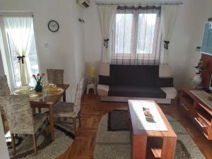 ein Wohnzimmer mit einem Sofa und einem Tisch in der Unterkunft DORA Apartman in Palić