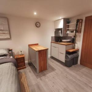 uma cozinha com uma cama e um balcão num quarto em Luxury cabin with hot-tub em Cheltenham