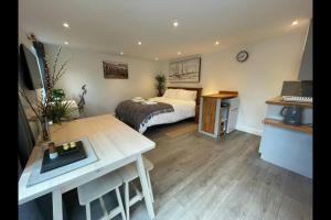 a bedroom with a bed and a table in it at Luxury cabin with hot-tub in Cheltenham