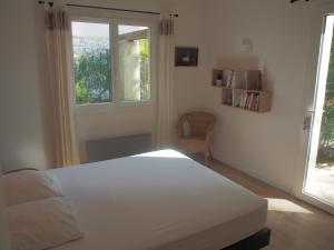 een slaapkamer met een wit bed en een raam bij Villa familiale - Proche Aix en Provence in Ventabren