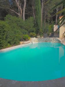 een zwembad met blauw water in een tuin bij Villa familiale - Proche Aix en Provence in Ventabren