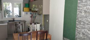 a kitchen with a wooden table and chairs and a counter at chambre dans maison colocation 20 min de Paris in Antony +3 photos