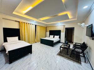 Habitación de hotel con 2 camas y TV en Grand Taj, en Murree