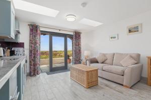a living room with a couch and a table at Ramsey Sea View Cottage - Dog Friendly in Pembrokeshire