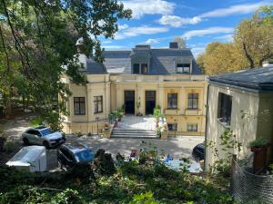 a large yellow house with cars parked in front of it at Villa Louis Hirsch in Gera