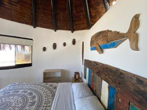 een slaapkamer met een bed en een houten vliegtuig aan de muur bij Marinus Eco Lodge in Canoas