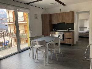 Residence La Corte di San Rocco في Cremeno: مطبخ وغرفة طعام مع طاولة وكراسي