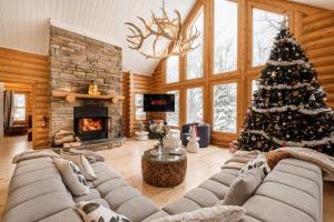 uma sala de estar com uma árvore de Natal e um sofá em Chalet Golden Bear - Fiddler Lake em Mille-Isles