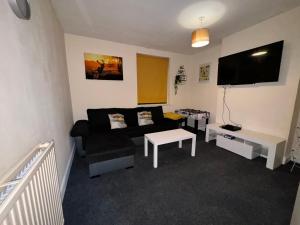 a living room with a couch and a flat screen tv at Students Contractors Professionals in Leicester