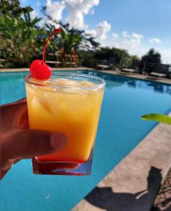 a hand holding a drink with a cherry on top at FINCA SAN ANTONIO in Pluma Hidalgo