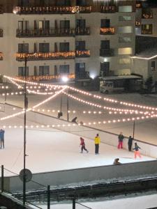 un gruppo di persone che pattinano su una pista di pattinaggio con luci di Tatra K2, app.42, Bakuriani a Bakuriani