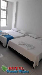 a room with three beds in a room at Hotel URUMITA MAGICA in Valledupar