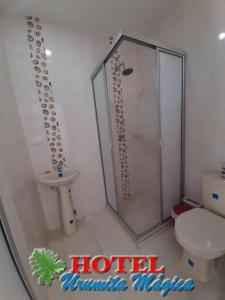 uma casa de banho com um chuveiro, um WC e um lavatório. em Hotel URUMITA MAGICA em Valledupar