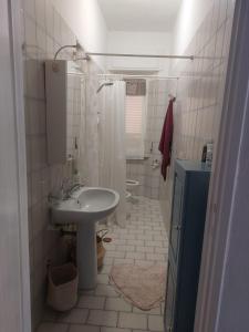 Baño blanco con lavabo y aseo en Casa di Gina en Rosignano Solvay