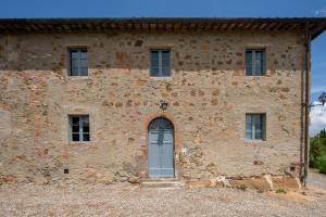 - un vieux bâtiment en pierre avec une porte bleue dans l'établissement I Sodi di Bibbiano, à Lilliano