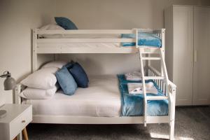 a bedroom with two bunk beds and a ladder at Oak House - sleeps 10 with Bar & Games room in Reighton