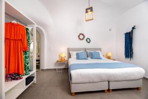 1 dormitorio con 1 cama con sábanas azules y naranjas en Whitewashed Houses en Mesariá