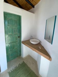 baño con lavabo y puerta verde en Marinus Eco Lodge, en Canoas