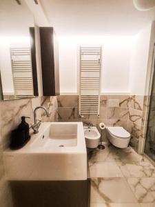 a bathroom with a sink and a toilet at Porta Nuova Apartment in Milan