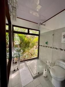 een badkamer met een toilet en een glazen tafel bij CABAÑAS DEL LAGO / BUNGALOWS in San Ramón