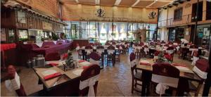 a dining room with tables and chairs in a building at Nuestras Raíces Hotel - Museo - Restaurante in San Cristóbal de Las Casas