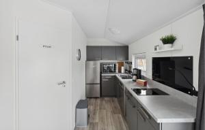 a kitchen with stainless steel appliances and gray cabinets at Charlet in Süsel