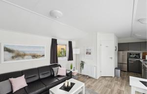 a living room with a black couch and a kitchen at Charlet in Süsel