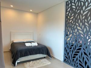 een slaapkamer met een bed met een zwart-witte muur bij Apartamento na Montanha em Campos in Campos do Jordão
