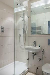 a bathroom with a shower and a sink at A Grand Four Bedroom Townhouse at Knightsbridge in London