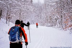 a group of people cross country skiing in the snow at Hotel Le Petit Lac Sainte-Adèle in Sainte-Adèle
