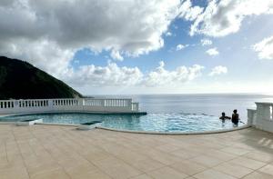 a swimming pool with a view of the ocean at ElDorado Guesthouse in Roseau
