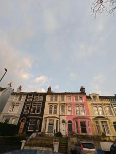 een rij huizen in een straat met auto's aan de voorkant bij Feel Like Your Home in Hastings