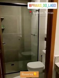 Praias do Lago Eco Resort 1 quarto في كالدس نوفاس: حمام مع مرحاض وباب دش زجاجي