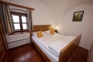 a bedroom with a bed with white sheets and a window at Wine Grower's Mansion Zlati Gric in Slovenske Konjice