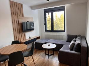 a living room with a couch and a table at Grand Casa Apartments in Jahorina
