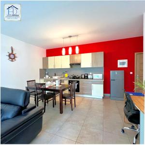 a kitchen and dining room with red walls and a table and chairs at E&D Apartments in Antananarivo