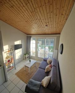un soggiorno con divano blu e soffitto in legno di Appartement T2 à Port-Bourgenay Résidence île au pré a Talmont