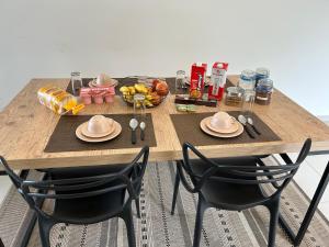 a wooden table with two chairs and a tray of food at Apartamento na Montanha em Campos in Campos do Jordão