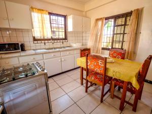 una cocina con mesa, sillas, mesa, mesa y silla en Impeccable 2-Bed Apartment in Paramaribo, en Paramaribo