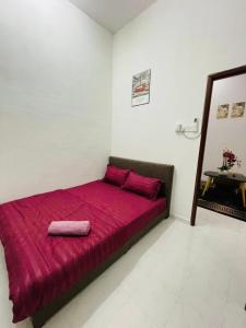 a bed with a red blanket on it in a room at Tok Mak Homestay Bukit Mertajam in Kubang Semang