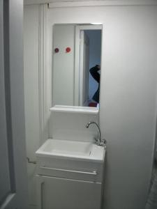 een witte badkamer met een wastafel en een spiegel bij The good life 1 in Senlis