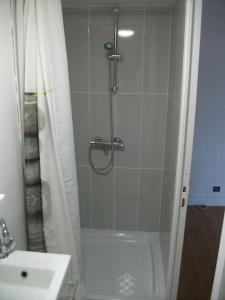 een douche met een glazen deur naast een wastafel bij The good life 1 in Senlis