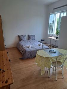 a bedroom with a bed and a table in it at The good life 1 in Senlis