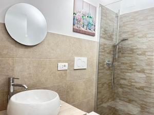La salle de bains est pourvue d'un lavabo et d'une douche avec un miroir. dans l'établissement Da Mauro & Michela a Tor Vergata, à Rome