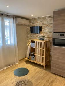 un soggiorno con cucina completa di TV e bancone di Sea sand and sun Studio La Madrague a Saint-Cyr-sur-Mer